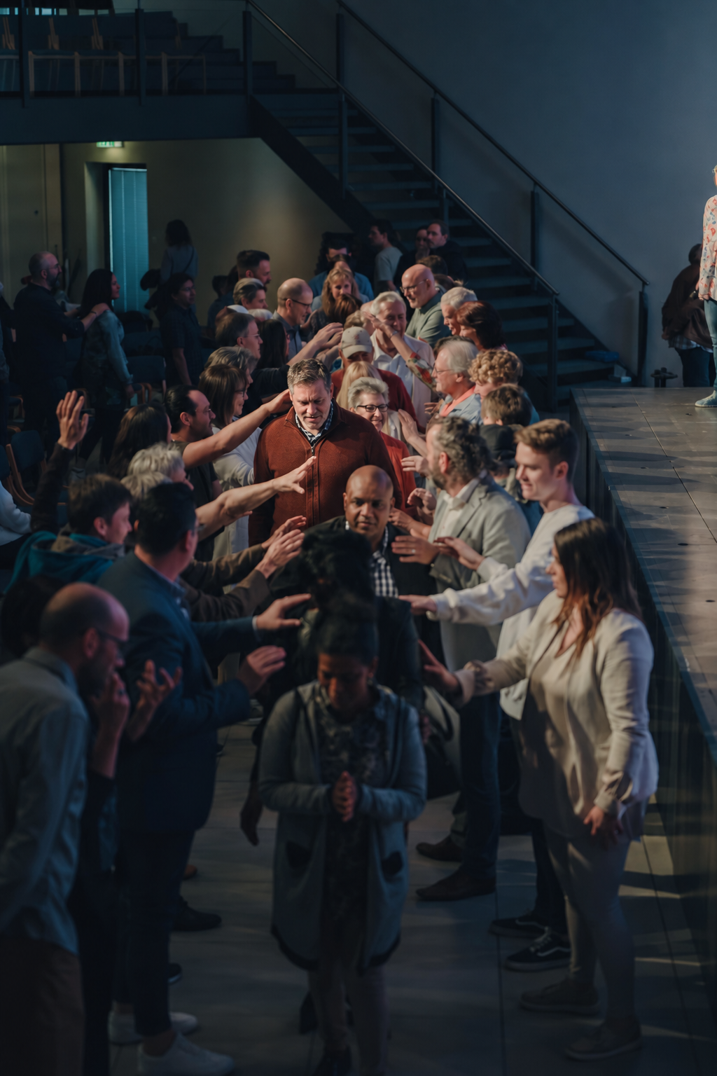 A congregation praying over attendees during ministry